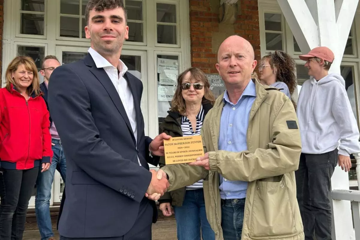Alex Thomas (club secretary) receiving the plaque from Ross Fenton